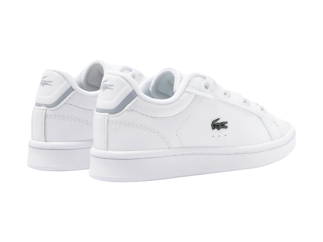 Tenis blancos Lacoste Carnaby Pro con logotipo de cocodrilo verde en el lateral.