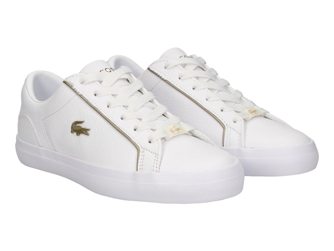Tenis blancos de cuero marca Lacoste con cordones y logo del cocodrilo en el costado.