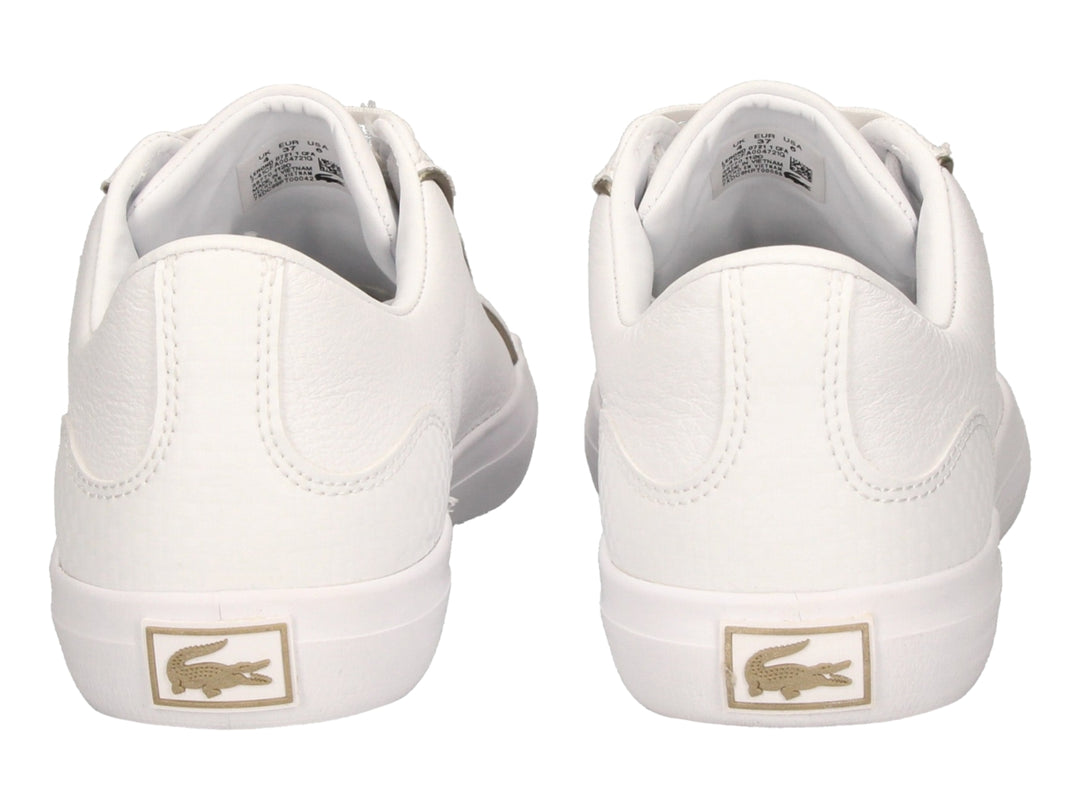 Tenis blancos de cuero marca Lacoste con cordones y logo del cocodrilo en el costado.
