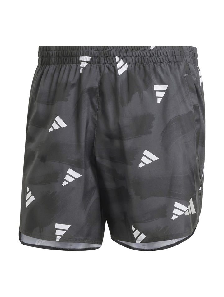 Hombre vistiendo shorts deportivos Adidas color negro con estampado de logos blancos.