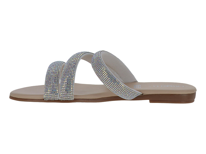 Sandalia plana color plata con tiras brillantes y suela beige.