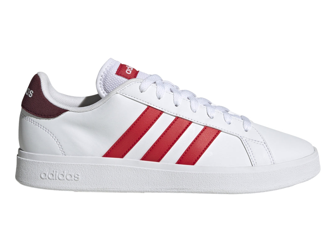 Tenis Adidas blancos con tres franjas rojas laterales y detalle en el talón en color rojo oscuro.
