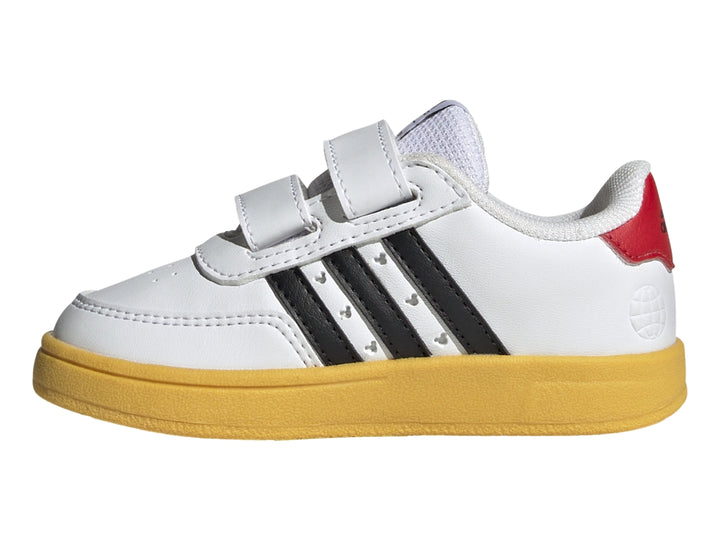 Tenis blancos Adidas para niño con suela amarilla, franjas negras y diseño de Mickey Mouse con cierres de velcro.