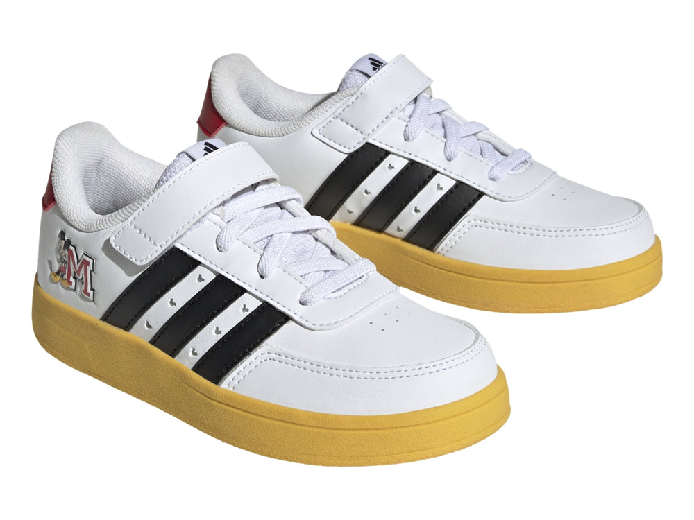 Tenis Adidas blancos con suela amarilla, franjas negras y gráfico de Mickey Mouse.