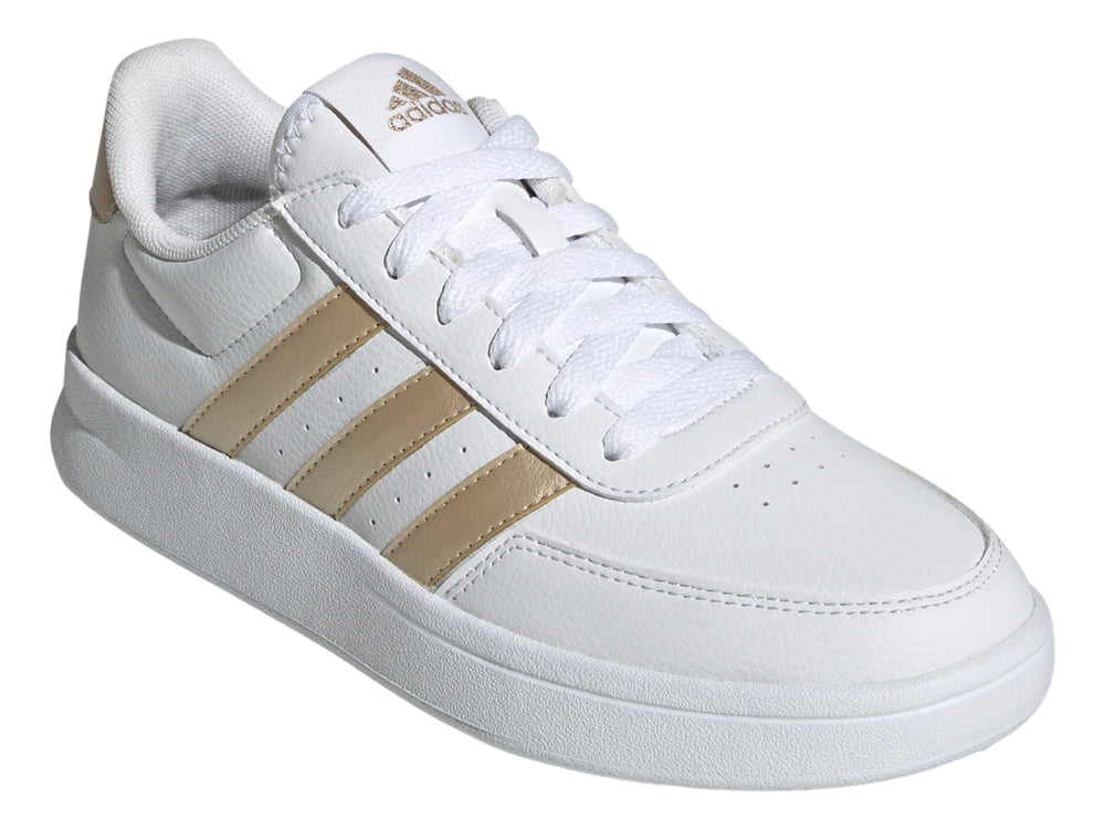 Tenis Adidas blancos con franjas laterales y detalle en el talón en color dorado.