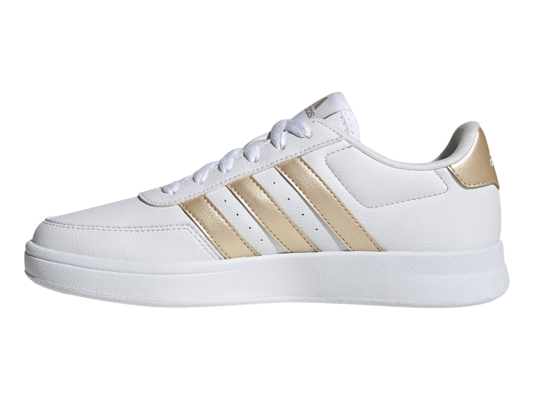 Tenis Adidas blancos con franjas laterales y detalle en el talón en color dorado.