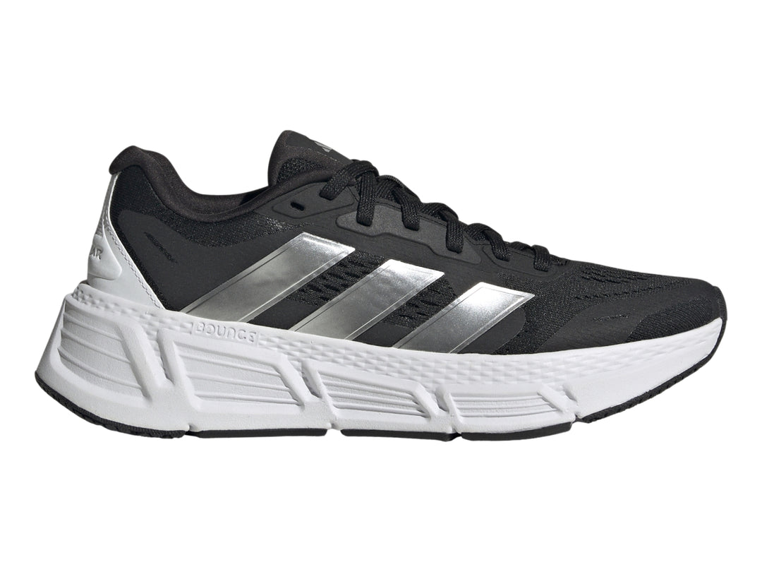 Tenis deportivos Adidas Questar 2 en color negro con suela blanca y tres franjas plateadas laterales.