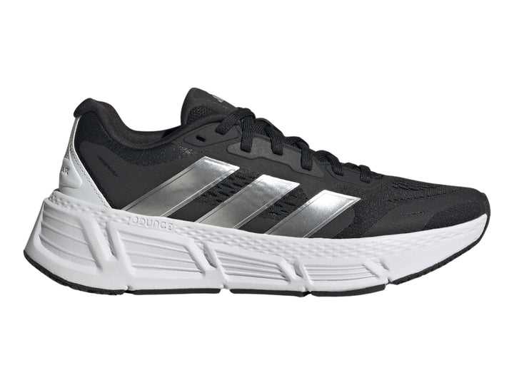 Tenis deportivos Adidas Questar 2 en color negro con suela blanca y tres franjas plateadas laterales.