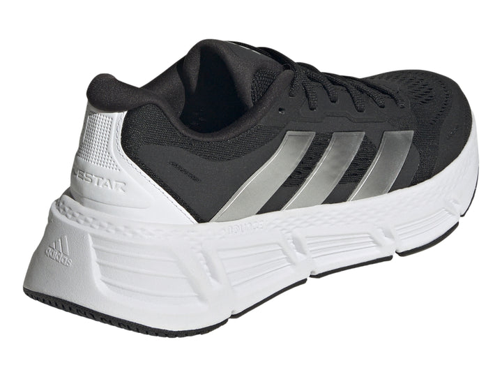 Tenis deportivos Adidas Questar 2 en color negro con suela blanca y tres franjas plateadas laterales.