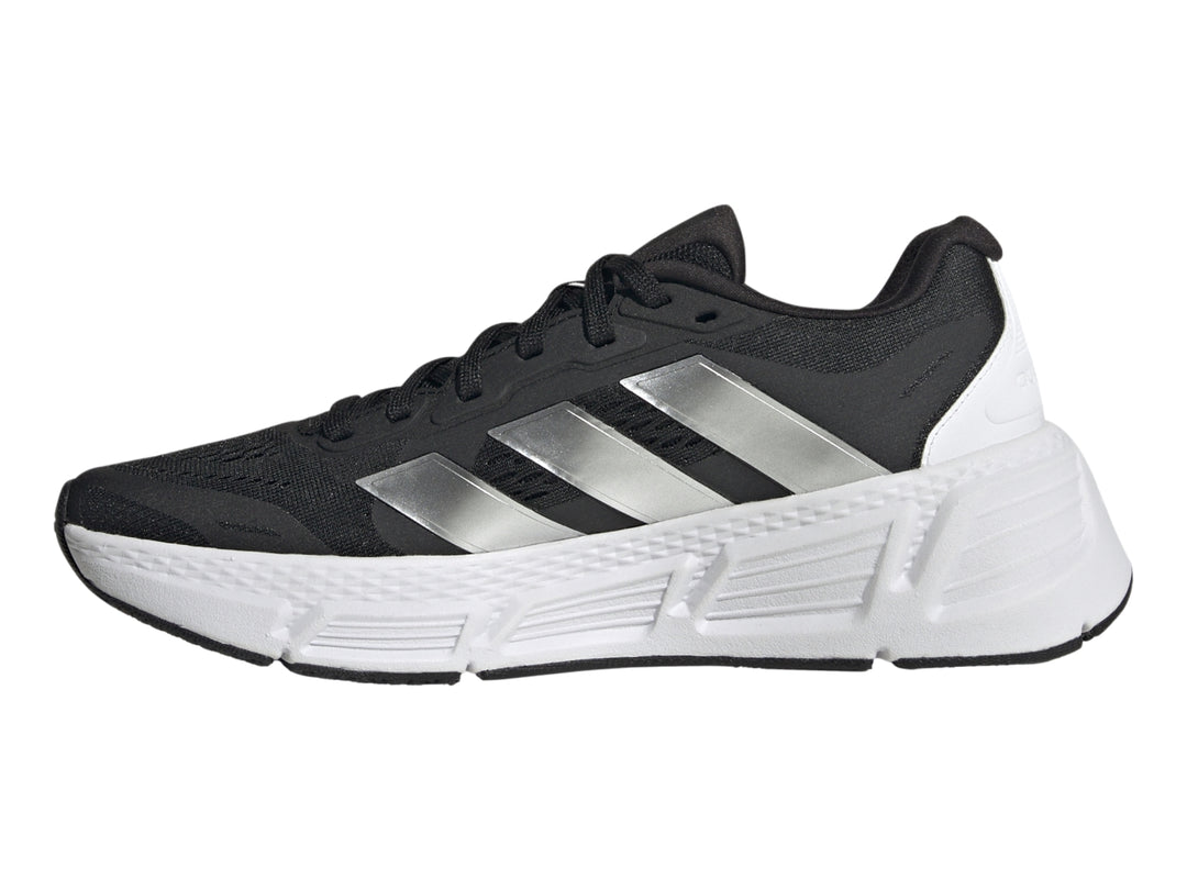 Tenis deportivos Adidas Questar 2 en color negro con suela blanca y tres franjas plateadas laterales.