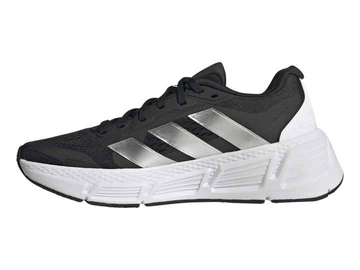 Tenis deportivos Adidas Questar 2 en color negro con suela blanca y tres franjas plateadas laterales.