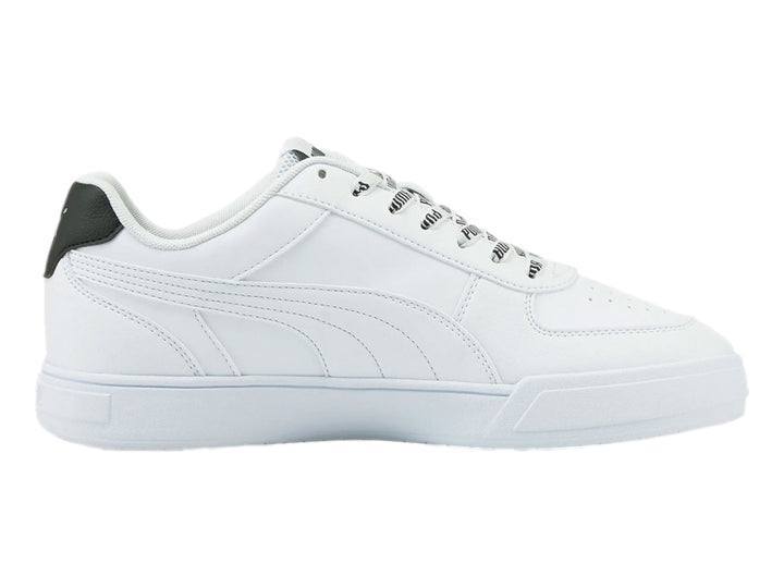 Tenis PUMA Caven Logomania color blanco con detalle negro en el talón y suela blanca.