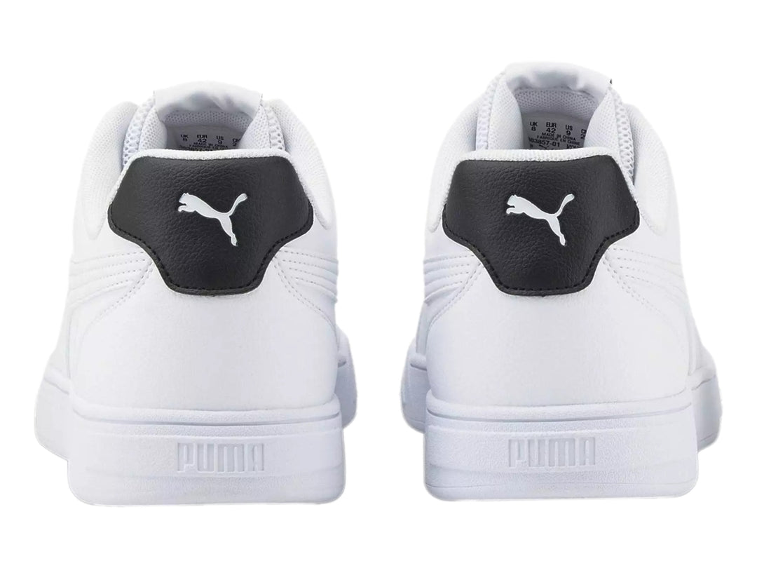 Tenis PUMA Caven Logomania color blanco con detalle negro en el talón y suela blanca.
