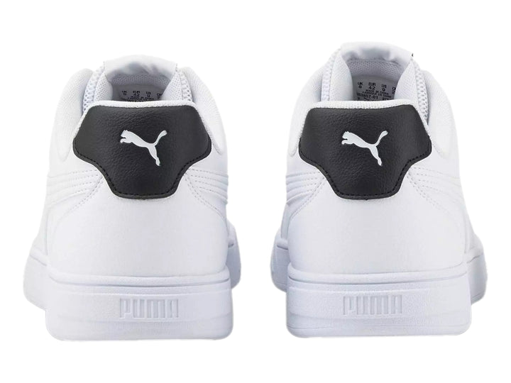 Tenis PUMA Caven Logomania color blanco con detalle negro en el talón y suela blanca.