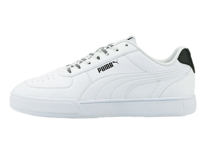 Tenis PUMA Caven Logomania color blanco con detalle negro en el talón y suela blanca.