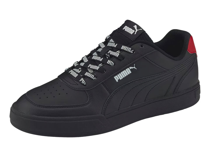 Tenis PUMA Caven Logomania color negro con detalle rojo en el talón y agujetas con texto blanco.
