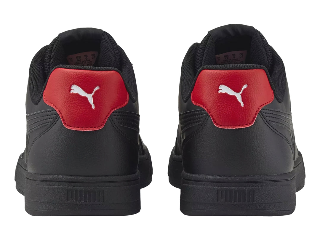 Tenis PUMA Caven Logomania color negro con detalle rojo en el talón y agujetas con texto blanco.