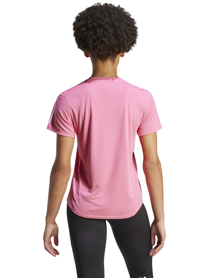 Camiseta deportiva Adidas color rosa fusión con detalles blancos en los hombros.