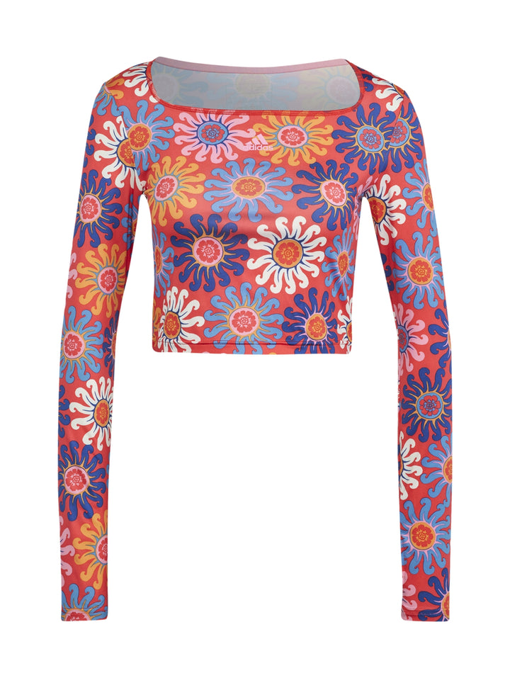 Mujer vistiendo un crop top deportivo de manga larga con estampado floral multicolor.