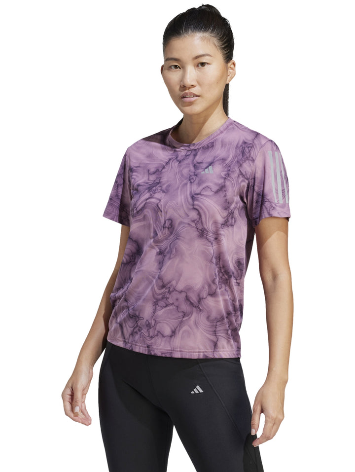 Camiseta deportiva Adidas color morado con estampado abstracto tipo mármol y mangas cortas.
