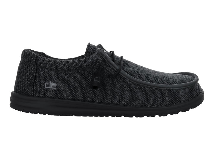 Zapato casual Hey Dude Wally Sox en color negro total con acabado tejido y suela negra.