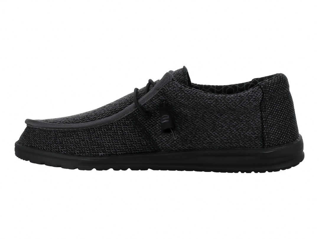 Zapato casual Hey Dude Wally Sox en color negro total con acabado tejido y suela negra.