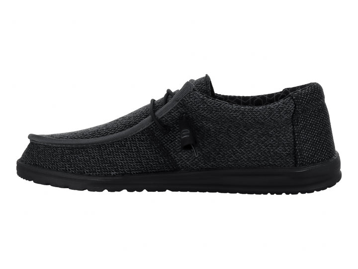Zapato casual Hey Dude Wally Sox en color negro total con acabado tejido y suela negra.
