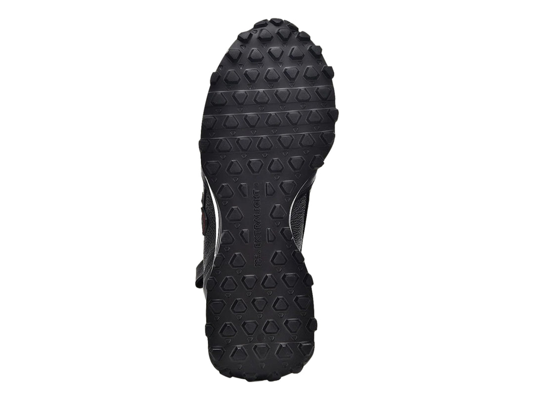 Tenis de cuero negro con suela blanca y detalles rojos laterales.