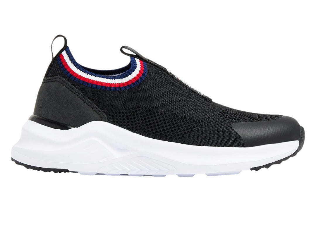 Tenis deportivos Tommy Hilfiger color negro con suela blanca y detalle tricolor en el cuello.