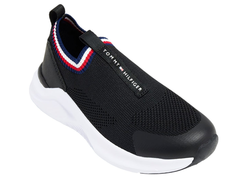 Tenis deportivos Tommy Hilfiger color negro con suela blanca y detalle tricolor en el cuello.