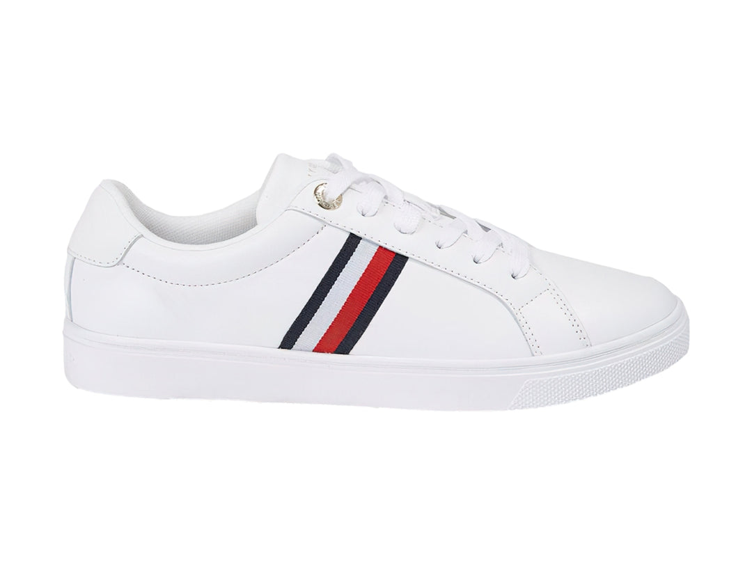 Tenis Tommy Hilfiger blancos con franjas azul y roja en el lateral y suela blanca.