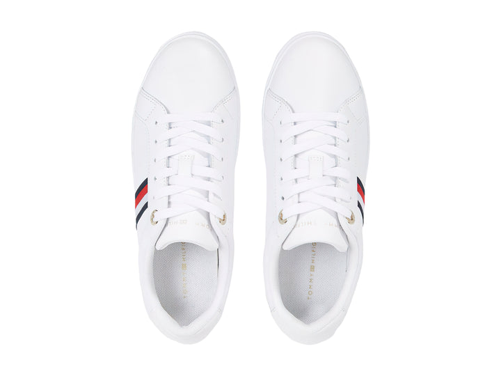 Tenis Tommy Hilfiger blancos con franjas azul y roja en el lateral y suela blanca.
