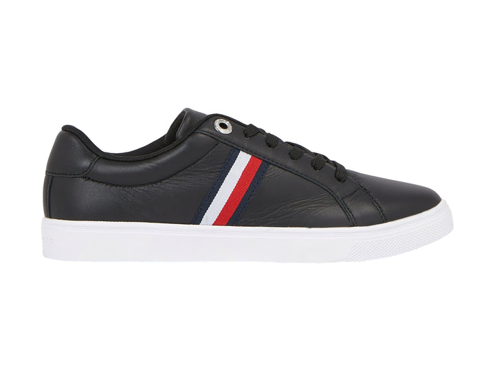 Tenis Tommy Hilfiger color negro con suela blanca y franjas laterales en rojo, blanco y azul.