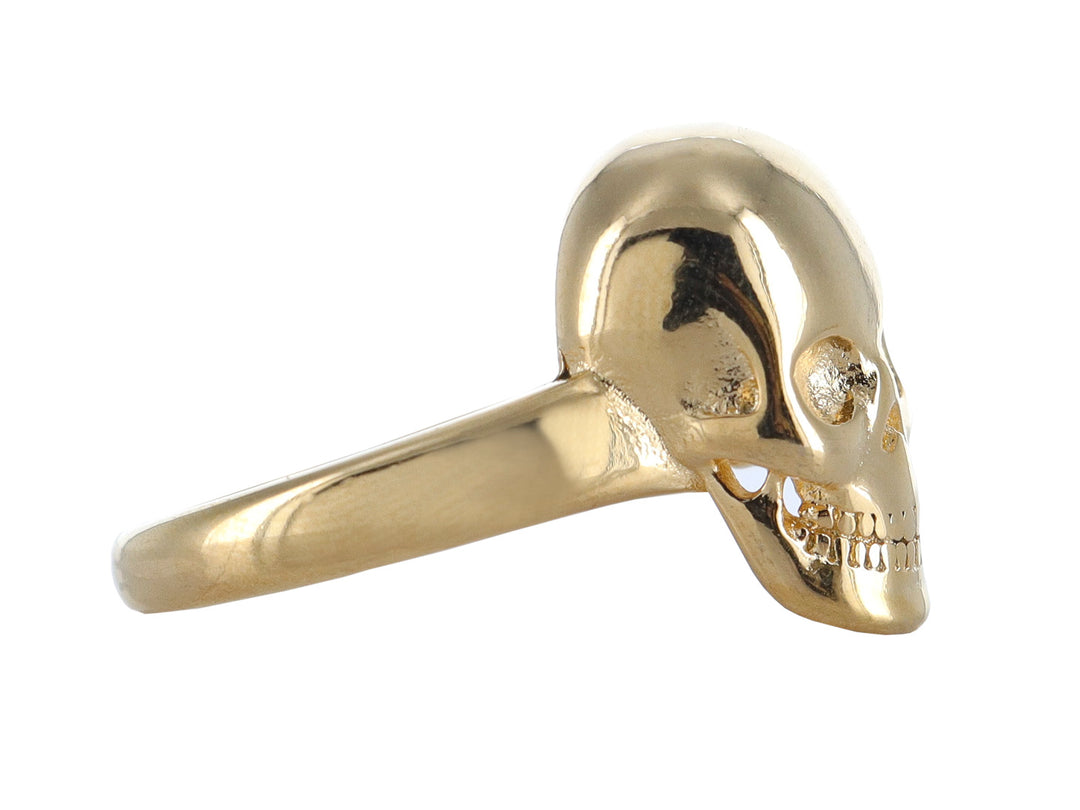 Anillo dorado con diseño de calavera detallada y acabado brillante sobre fondo blanco.