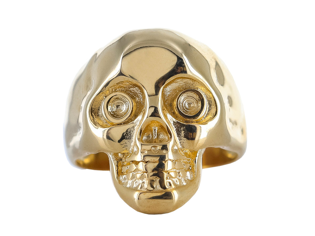Anillo dorado con diseño detallado de calavera en acabado brillante.