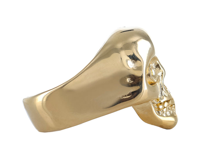 Anillo dorado con diseño detallado de calavera en acabado brillante.