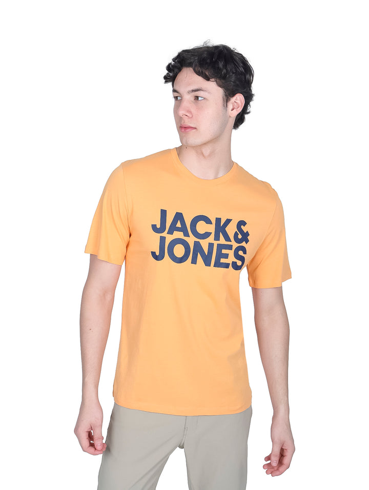 Hombre vistiendo playera naranja de manga corta con logo Jack &amp; Jones y pantalones beige.