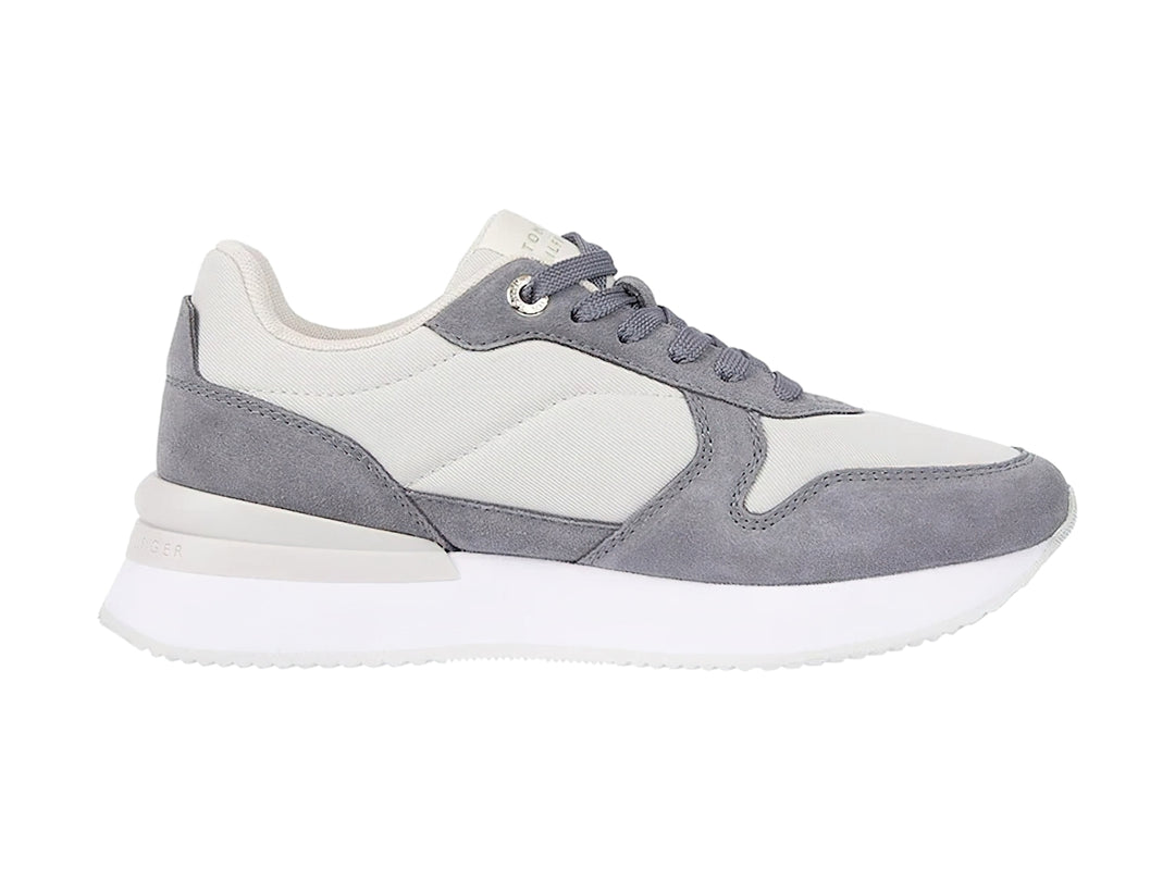 Tenis Tommy Hilfiger color gris fósil con suela blanca y detalles en tela y sintético para mujer.