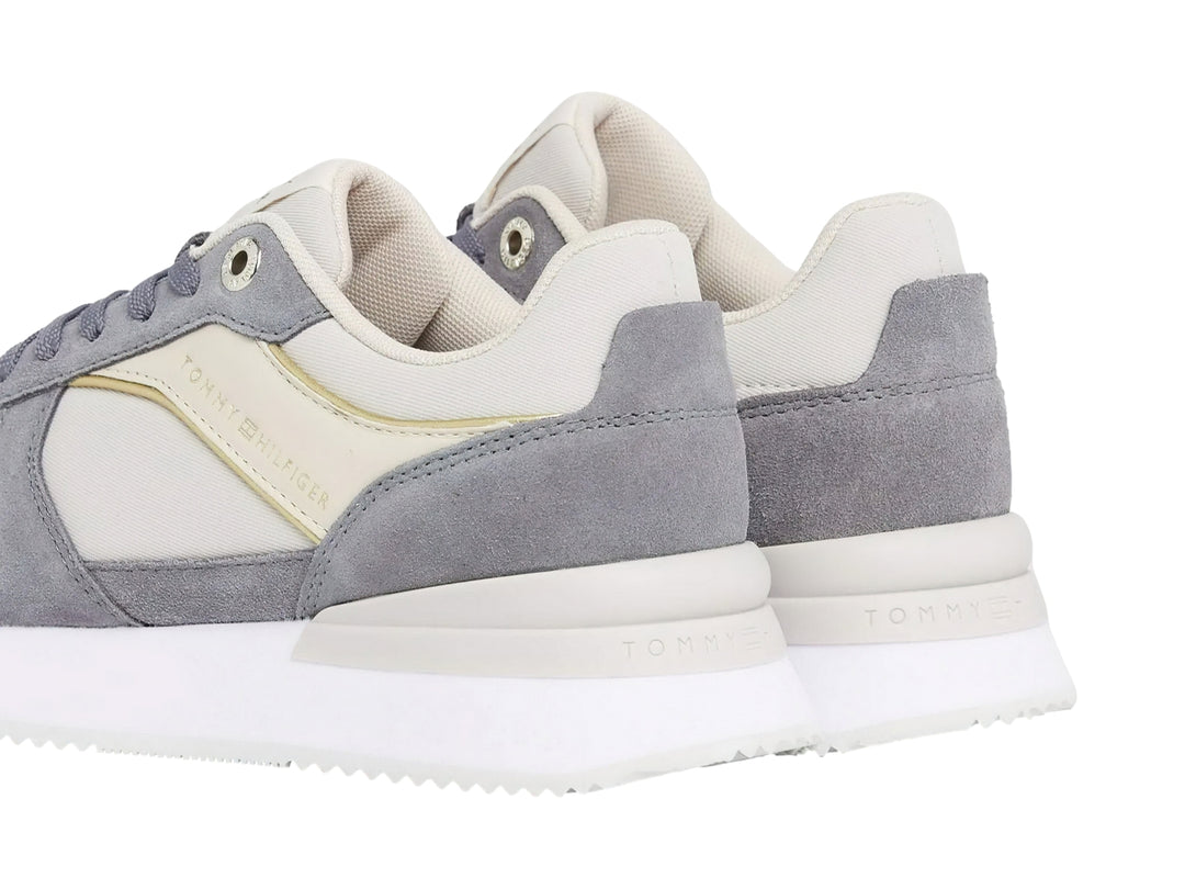 Tenis Tommy Hilfiger color gris fósil con suela blanca y detalles en tela y sintético para mujer.