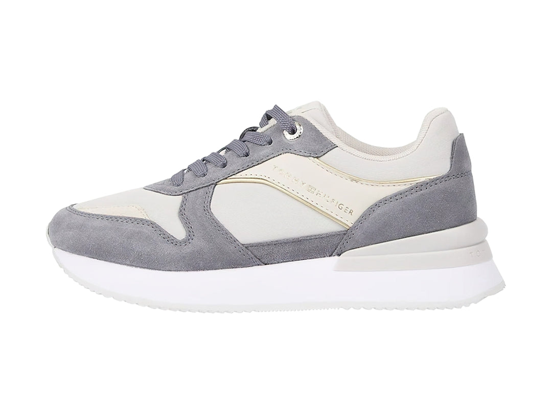 Tenis Tommy Hilfiger color gris fósil con suela blanca y detalles en tela y sintético para mujer.