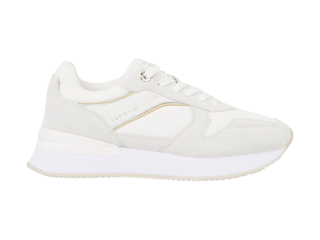Tenis blancos Tommy Hilfiger Elevated Feminine Runner con detalles dorados y suela blanca.