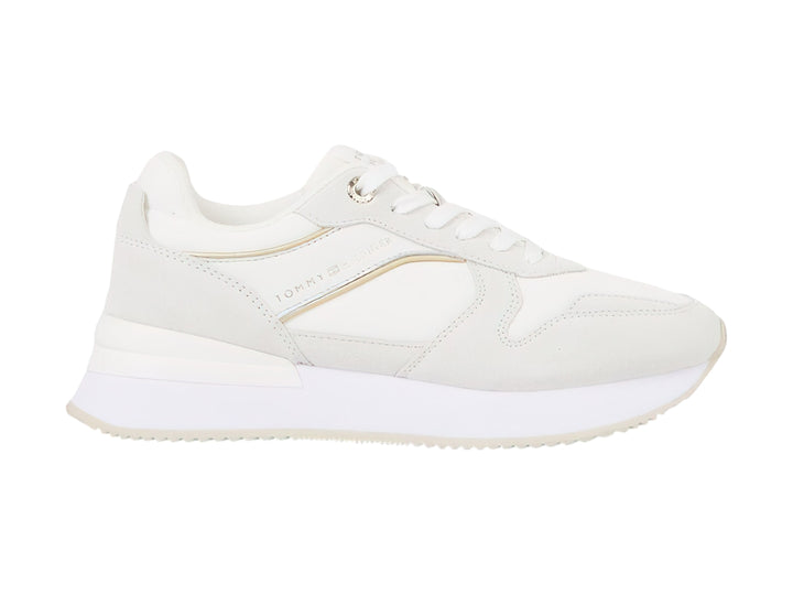 Tenis blancos Tommy Hilfiger Elevated Feminine Runner con detalles dorados y suela blanca.