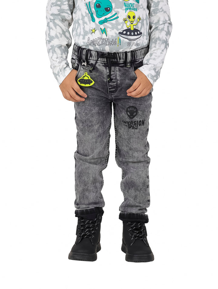 Pantalón de mezclilla gris para niño con estampado de alienígena y accesorio colgante.
