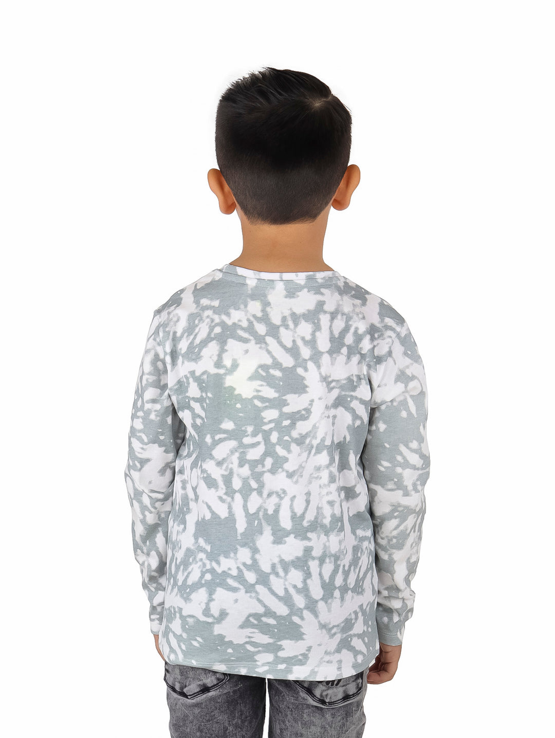 Niño vistiendo camiseta manga larga blanca y gris con efecto tie-dye y estampado de alienígenas y ovnis.