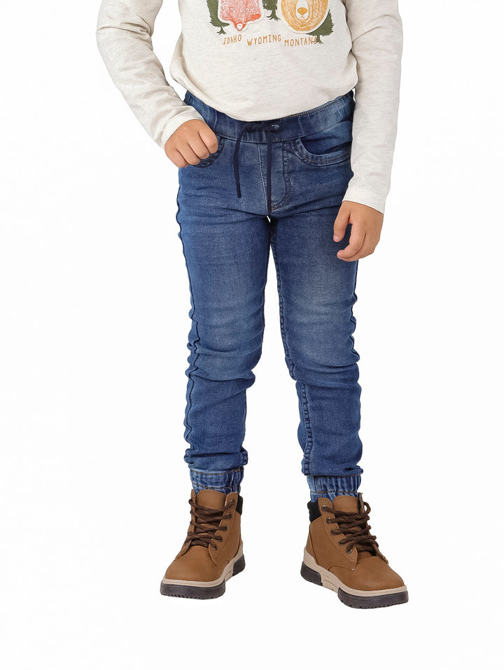 Pantalón denim azul estilo jogger para niño con cintura elástica y puños ajustados.