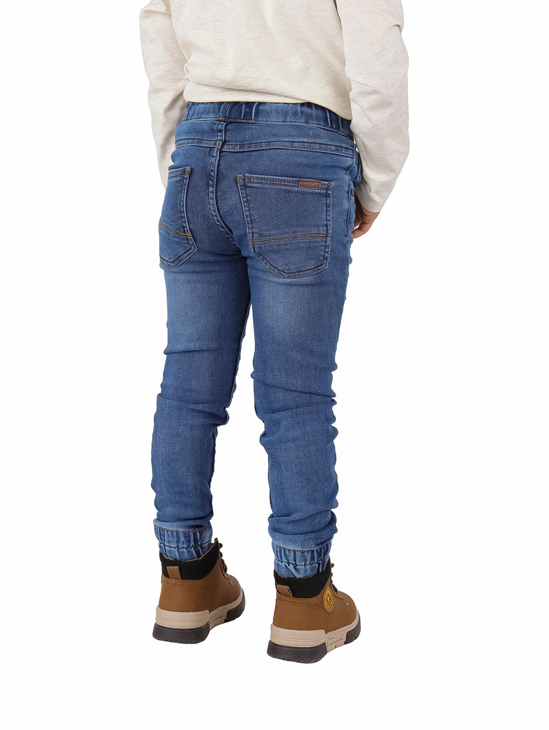 Pantalón denim azul estilo jogger para niño con cintura elástica y puños ajustados.