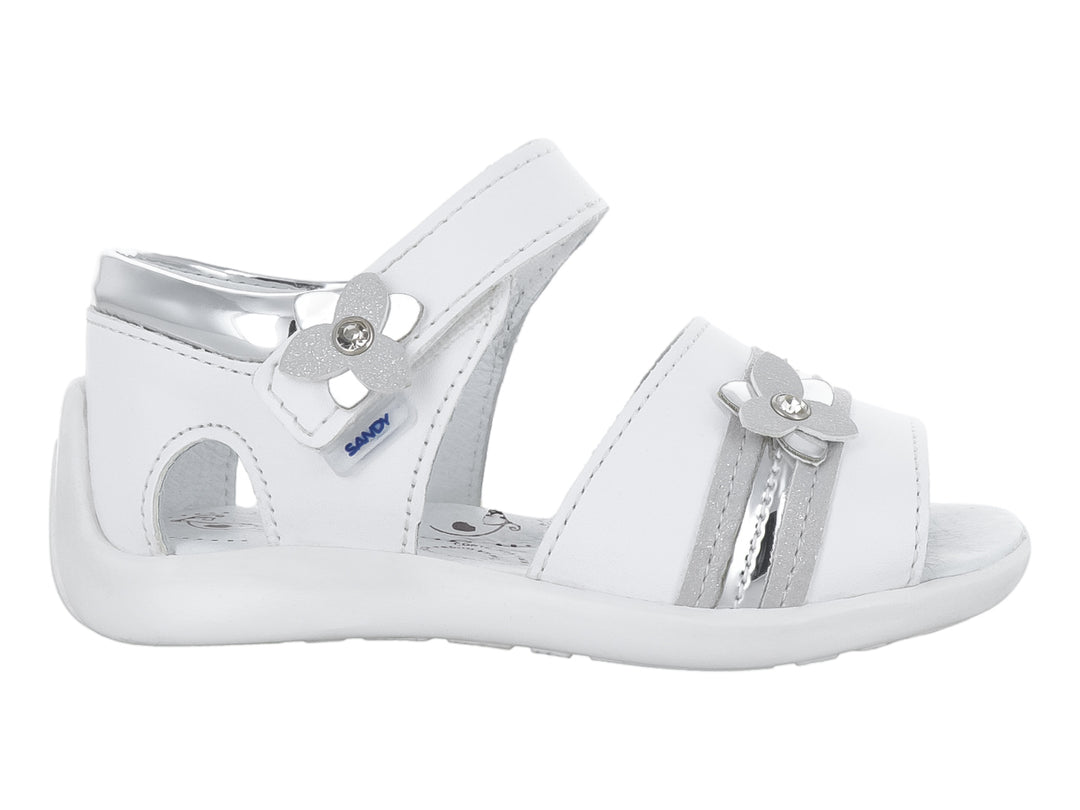 Sandalia blanca para niña con adornos de flores plateadas y correa de ajuste con velcro.