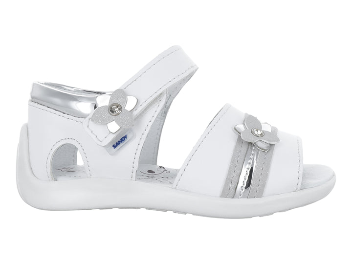 Sandalia blanca para niña con adornos de flores plateadas y correa de ajuste con velcro.
