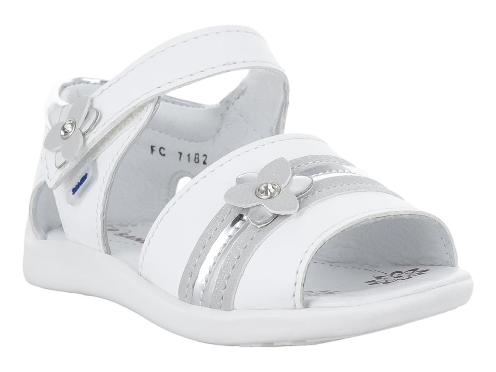 Sandalia blanca para niña con adornos de flores plateadas y correa de ajuste con velcro.