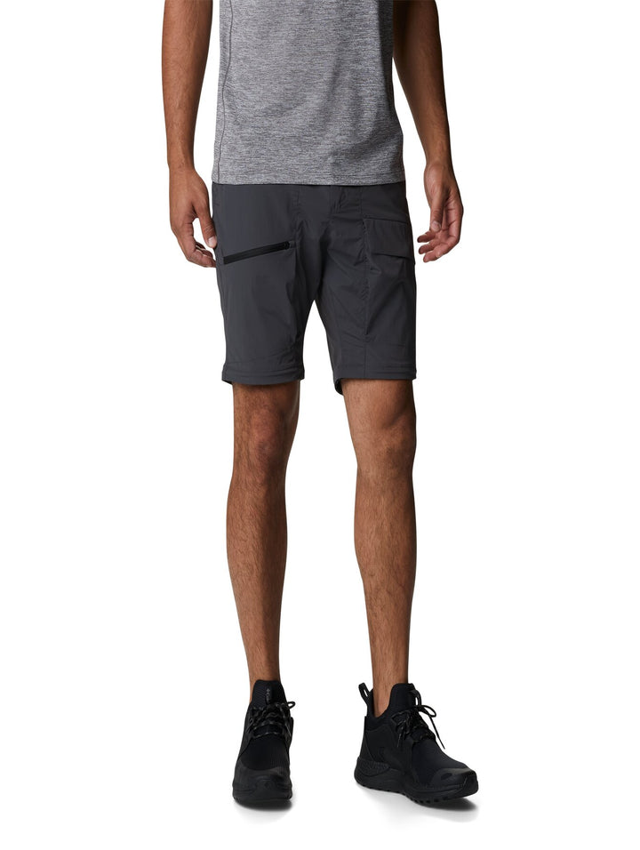 Hombre vistiendo pantalones Columbia color gris oscuro con función convertible mediante cremallera en la rodilla.